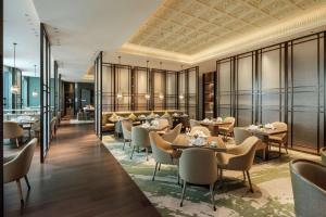 a restaurant with tables and chairs in a room at Hilton Chengdu Chenghua in Chengdu