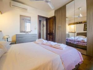 1 dormitorio con 1 cama blanca grande y toallas. en La Casina di Rosi vivere nellantico borgo en Castiglione della Pescaia
