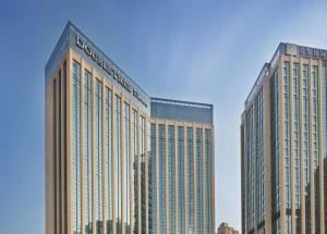 two tall buildings in front of a blue sky at Doubletree By Hilton Chengdu Longquanyi in Chengdu