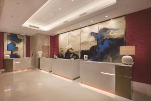 a lobby of a hotel with paintings on the walls at Doubletree By Hilton Chengdu Longquanyi in Chengdu