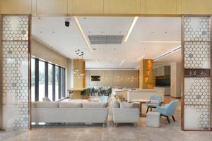 uma sala de estar com um sofá e cadeiras e uma cozinha em Hilton Garden Inn Changzhou Xinbei em Changzhou