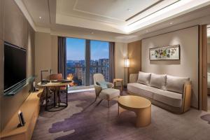 a living room with a couch and a large window at Doubletree By Hilton Chengdu Longquanyi in Chengdu