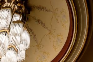 un lampadario appeso a una parete con carta da parati floreale di Home Sicilia24 a Catania Altre 15 foto