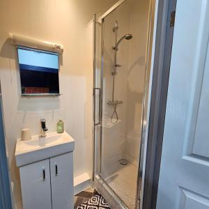 a bathroom with a shower and a sink at Goonearl Simply Stay in Scorrier