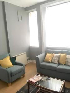 a living room with two couches and a coffee table at Logie Green - beautiful and central one bed flat in Edinburgh