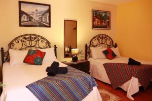 1 dormitorio con 2 camas y espejo en Casa Quetzalli, La Recolección en Antigua Guatemala