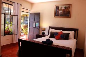1 dormitorio con 1 cama y puerta que da a un patio en Casa Quetzalli, La Recolección en Antigua Guatemala