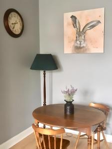 a table with a lamp and a clock on a wall at Logie Green - beautiful and central one bed flat in Edinburgh