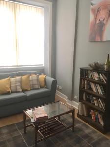 a living room with a couch and a coffee table at Logie Green - beautiful and central one bed flat in Edinburgh
