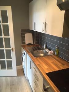 a kitchen with a sink and a washing machine at Logie Green - beautiful and central one bed flat in Edinburgh