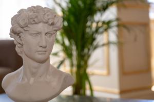 un busto bianco di un uomo davanti a una pianta di Home Sicilia24 a Catania