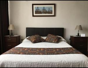 a bedroom with a bed with two nightstands and two lamps at La Casa De La Nonna in Quito