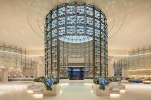 a lobby with a tall building with blue flowers at Hilton Dalian Golden Pebble Beach Resort in Jinzhou