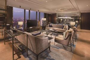 a living room with a couch and chairs and a television at Hilton Fuzhou in Fuzhou