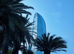 a tall building with palm trees in front of it at Hilton Haikou in Haikou