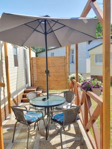stół i krzesła pod parasolem na patio w obiekcie Azur Domki blisko plaży w mieście Mielno
