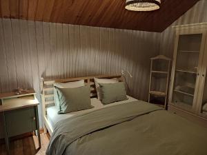 1 dormitorio con 1 cama y pared de madera en Casinha do pinhal, en Colares