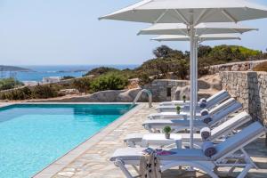 een rij ligstoelen met een parasol naast een zwembad bij Villa Dioni in Santa Maria