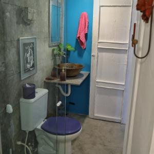 a bathroom with a toilet and a blue wall at CASA IRACEMAR in Fortaleza