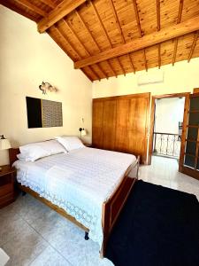 a bedroom with a large bed with a wooden ceiling at Casa Veronica - accogliente casa su due piani nel cuore del borgo in Làconi