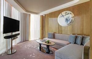sala de estar con sofá y TV en Conrad Hangzhou, en Hangzhou