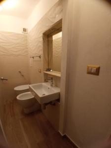 La salle de bains est pourvue d'un lavabo, de toilettes et d'un miroir. dans l'établissement A due passi dal Duomo, à Cefalù
