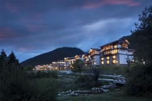 a large building on a hill at night at Hilton Linzhi Resort in Nyingchi