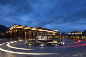 un bâtiment avec une fontaine devant lui la nuit dans l'établissement Hilton Linzhi Resort, à Nyingchi