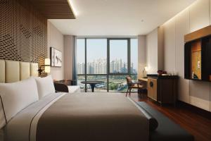 杭州的住宿－杭州金沙湖和達希爾頓嘉悅裡酒店，酒店客房设有一张床和一个大窗户