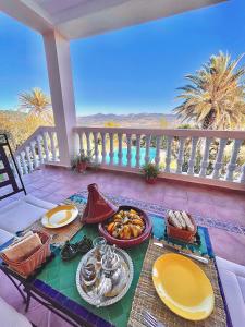 une table avec des assiettes de nourriture sur un balcon dans l'établissement Dar Bakkali Nadi, à Tanger