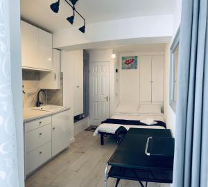 1 dormitorio con cama, mesa y cocina en CENTRAL HAVEN Minutes to Beach and Station, en Brighton & Hove