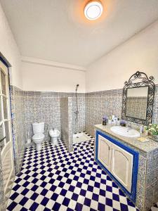 a bathroom with a sink and a toilet and a mirror at Dar Bakkali Nadi in Tangier