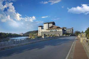 a road with a building on the side of a bridge at Hilton Huizhou Longmen Resort in Huizhou