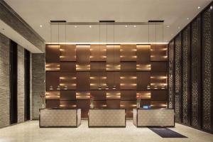 een lobby met bureaus en een muur met verlichting bij Hilton Huizhou Longmen Resort in Huizhou