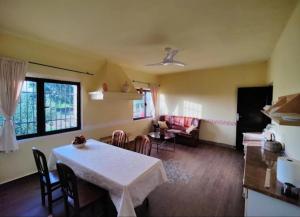 een keuken met een tafel en stoelen en een woonkamer bij Casa Rural Finca San Bernardo 3 estrellas in Montehermoso