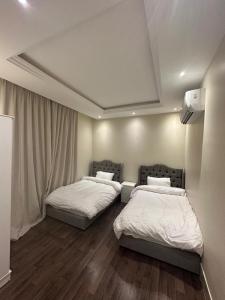 duas camas estão num quarto com avertisementalização em شقة نيرفانا ريزدنس Nirvana Residence Apt em Riyadh