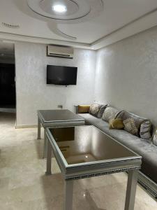 Marina saidia luxury Duplex pool & garden view في السعيدية: غرفة معيشة مع أريكة وتلفزيون بشاشة مسطحة