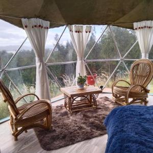 a room with three chairs and a bed and a table at glamping casa blanca in Guatavita
