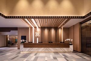 a lobby with a reception desk in a building at Hilton Garden Inn Jiuzhaigou in Jiuzhaigou