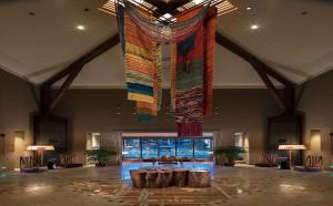 a large lobby with a large colorful chandelier hanging from the ceiling at Hilton Jiuzhaigou Resort in Jiuzhaigou