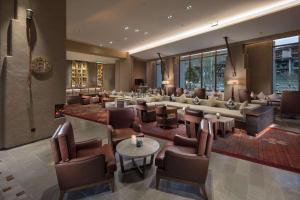 a hotel lobby with couches and tables and chairs at Hilton Jiuzhaigou Resort in Jiuzhaigou