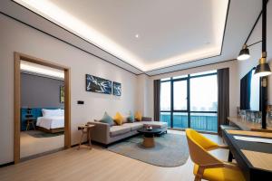 ein Wohnzimmer mit einem Sofa und einem Bett in der Unterkunft Hilton Garden Inn Nanchang in Nanchang
