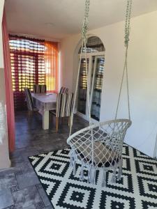 a porch with a swing and a table and chairs at Kuća na dan aseea 