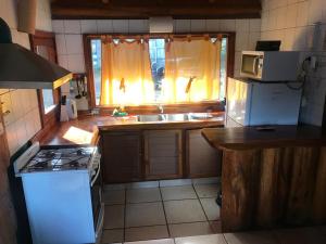 uma cozinha com um fogão, um lavatório e uma janela em Cabaña Las Alpinas em Villa La Angostura
