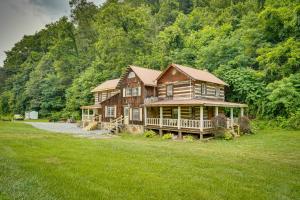 a large wooden house in the middle of a field at Historic Cabin Retreat about 2 Mi to Seneca Rocks! in Seneca Rocks