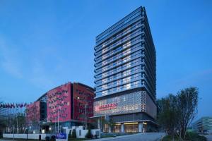 un grand bâtiment avec un panneau sur son côté dans l'établissement Hilton Garden Inn Zhuhai Hengqin, à Zhuhai