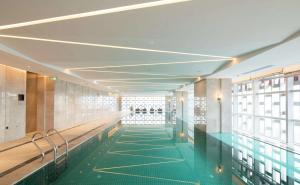 - un couloir avec piscine dans un bâtiment dans l'établissement Hilton Garden Inn Zhuhai Hengqin, à Zhuhai