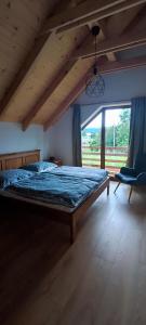 1 dormitorio con cama y ventana grande en Chata pod Barancom, en Smrečany