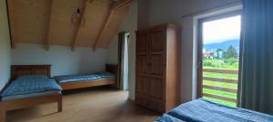 1 dormitorio con 2 camas y ventana grande en Chata pod Barancom, en Smrečany
