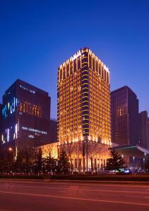 a tall building with lights on it at night at Hilton Nanjing in Nanjing